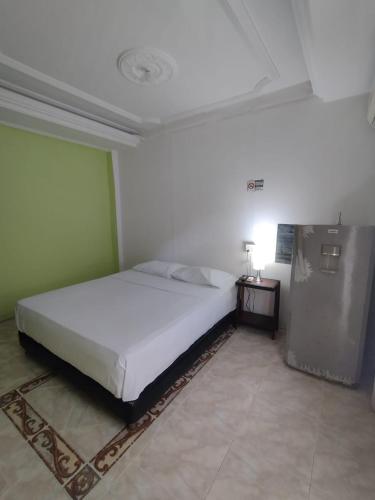 a bedroom with a white bed in a room at La fantástica Mi Hostal in Cartagena de Indias