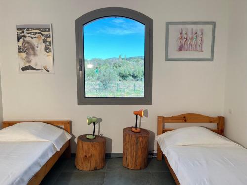 deux lits dans une chambre avec une fenêtre dans l'établissement Le poisson qui recule - Maison et piscine dans parc arboré proche mer, à Sanary-sur-Mer