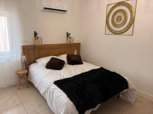 a bedroom with a bed with a black blanket on it at Saint Amour Appartement T2 in Lancié