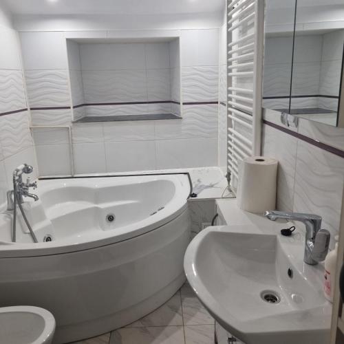 a white bathroom with a tub and a sink at Dom Kopernica 3 in Chełm
