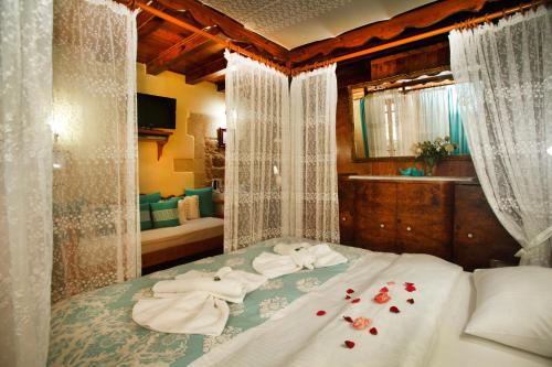 a bedroom with a bed with towels and roses on it at Palazzo di Pietro in Chania Town
