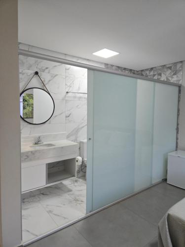 a bathroom with a sink and a mirror at AR Pousada in Santa Bárbara
