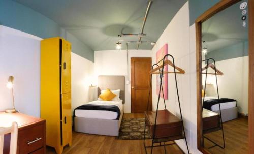 a small bedroom with a bed and a mirror at ILAR 74 Coliving & Hotel Avenida Chile Bogota in Bogotá