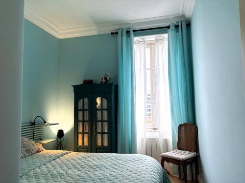 une chambre avec des murs bleus et un lit et une fenêtre dans l'établissement Appartement familial hyper bien situé, à Annecy