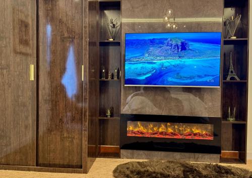 a living room with a television and a fireplace at Grand Berkshire Signature Hotel operated by Berkshire Hotels & Resorts UK in Islamabad