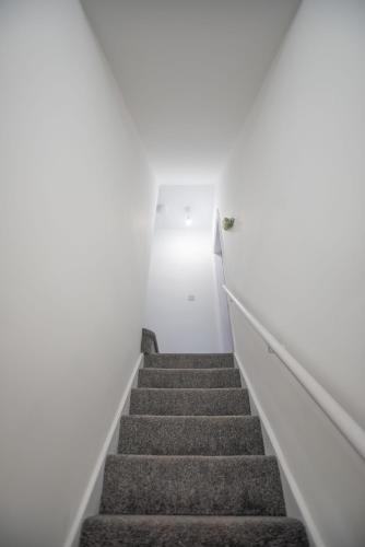 a stairway in a white room with stairs at Harrison Hideaway in Carlisle