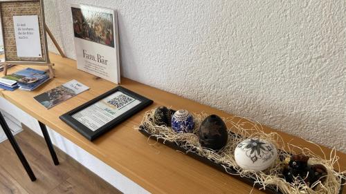 a table with a shelf with vases on it at Naturnahe Familienwohnung in Rüschegg-Graben