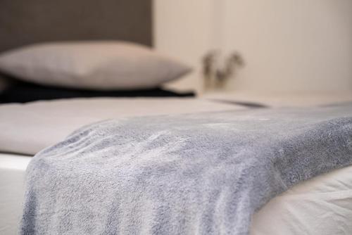 a bed with white sheets and pillows on it at Bogdanović Winery Apartman in Ilok