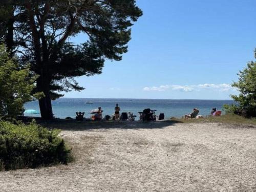 a group of people sitting on a beach near the water at Apartment with balcony in Sölvesborg in Sölvesborg
