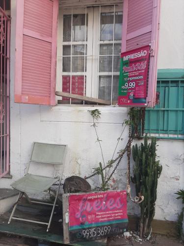 a chair and a sign in front of a building at Cytau mesa de trabalho e sofá-cama com ar condicionado, café, wi-fi e água liberados, acesso fácil in Porto Alegre