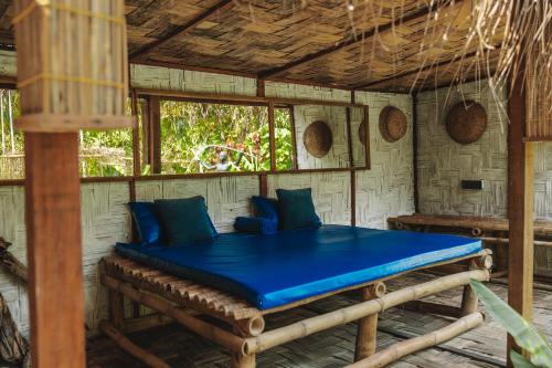 a room with a blue bed in a room with windows at SatyaVilla6 in Havelock Island
