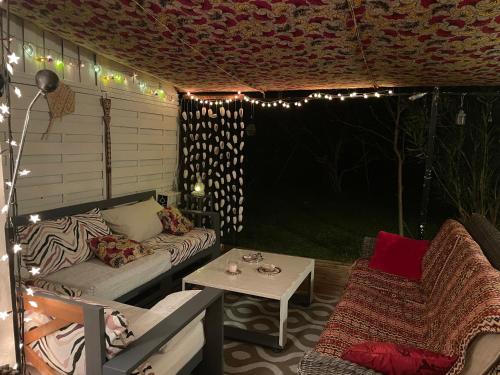 a patio with a couch and a table with lights at La Chambre Du Voyageur in Soustons
