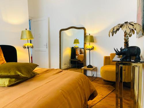 a bedroom with a bed and a mirror and a chair at Hôtel VCB Ciney Centre-ville in Ciney