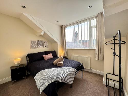 a bedroom with a bed and a large window at Ocean Apartment, Spacious 5 bedroom holiday home in Whitley Bay