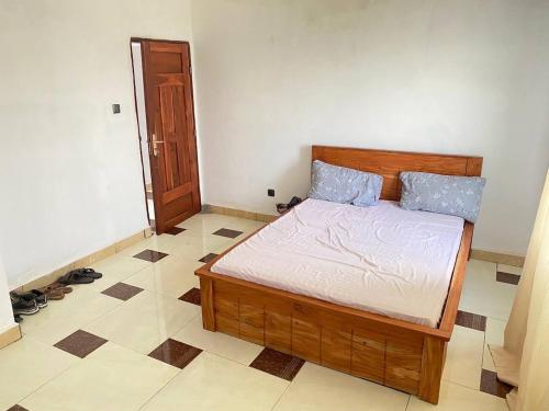 een slaapkamer met een houten bed in een kamer bij Litos place in Cotonou