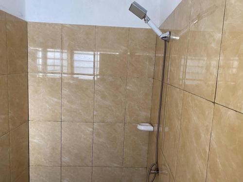 een douche met een douchekop in een badkamer bij Litos place in Cotonou