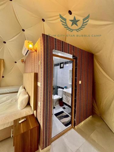 a room with a tent with a bed and a mirror at RUM CITY STAR BUBBLE lUXURY CAMP in Wadi Rum