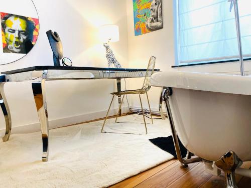 a room with a table and a bath tub and a table and chair at Hôtel VCB Ciney Centre-ville in Ciney