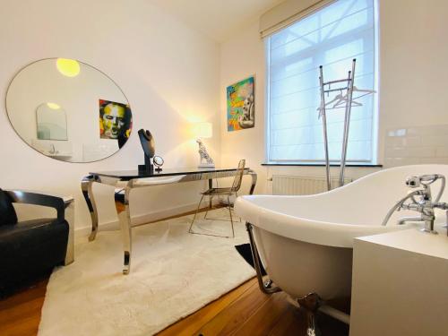a bathroom with a tub and a sink and a mirror at Hôtel VCB Ciney Centre-ville in Ciney