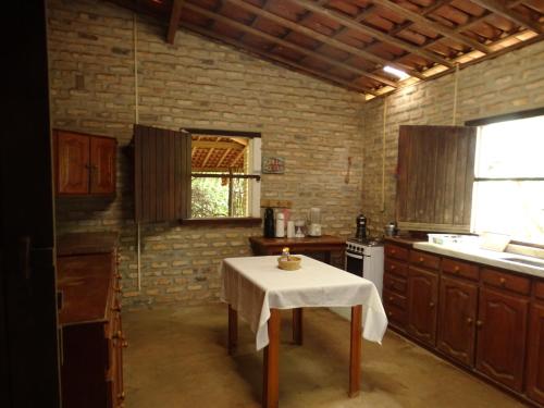 una cocina con mesa y mantel blanco. en Jungle House, en São Miguel do Gostoso