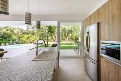 a kitchen with a sink and a refrigerator at Villa Pasha , dream villa in Xpuha , Riviera Maya in Xpu Ha