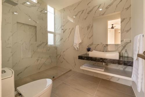 a bathroom with a white toilet and a sink at Villa Pasha , dream villa in Xpuha , Riviera Maya in Xpu Ha