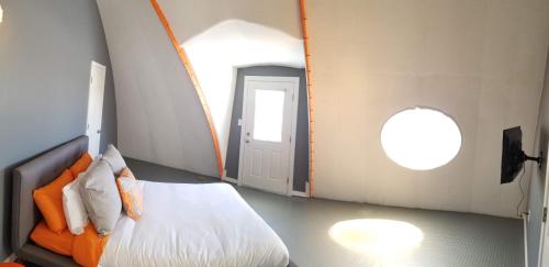 a bedroom with an orange bed and an open door at The Spaceship House! in Navarre