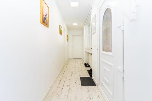 a hallway with white walls and a wooden floor at Bogdanović Winery Apartman in Ilok