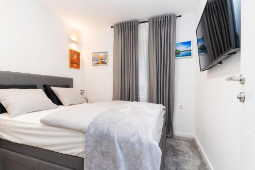 a bedroom with a bed with white sheets at Bogdanović Winery Apartman in Ilok