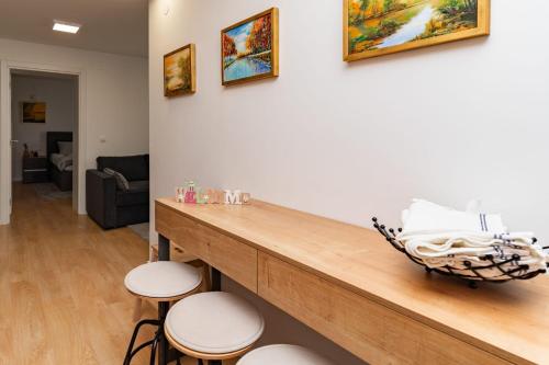 a room with a counter with stools and paintings on the wall at Bogdanović Winery Apartman in Ilok