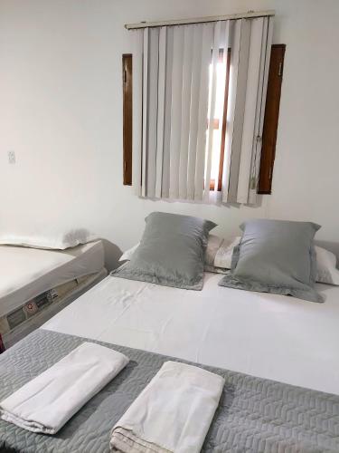 a bedroom with two beds and a window at Restaurante e Petiscaria Tucunaré Azul in Coruripe