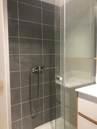 une douche avec une porte vitrée dans une salle de bain dans l'établissement Chambre meublée avec salle de bain privative, à Nantes