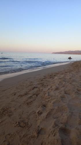 an empty beach with a boat in the water at Dedalos Beach n1 ground floor in Stalida