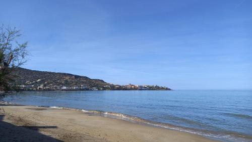 a beach with the ocean and a town in the distance at Dedalos Beach n1 ground floor in Stalida