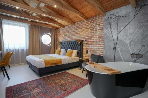 a bedroom with a large bed and a bath tub at ChaChaCha House Vendégház in Egerszalók