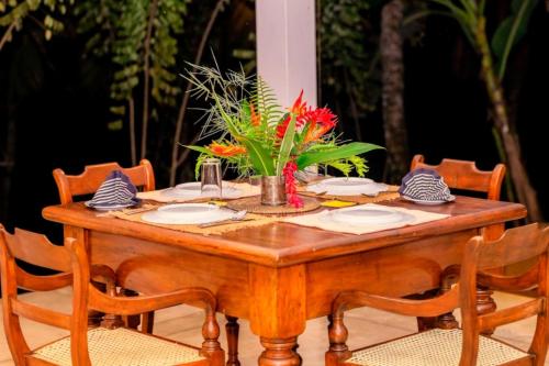 a wooden table with chairs around it with flowers on it at Halketha in Matugama