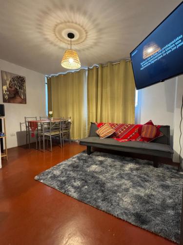 ein Wohnzimmer mit Sofa und Tisch in der Unterkunft Cuzco Lodgement in Lima