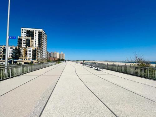 a bridge over the beach with buildings in the background at Need to relax! Do it here! in Wave Crest