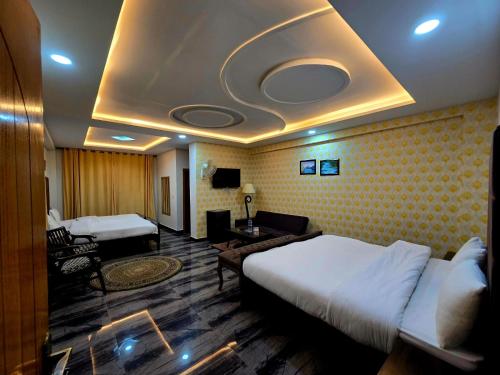 a hotel room with a bed and a living room at GrandTaj in Murree