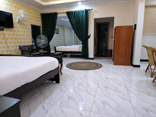 a hotel room with two beds and a television at GrandTaj in Murree