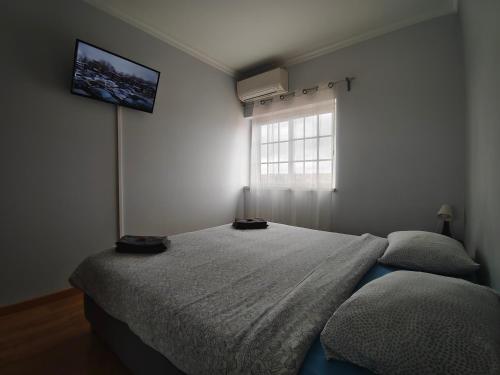 a bedroom with a bed and a window at Residencial Marialva Park in Corroios