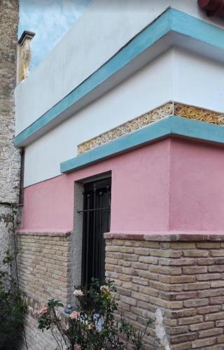 a pink and blue building with a window at Home4U Κερατέα apt3, just 17Km from airport in Keratea