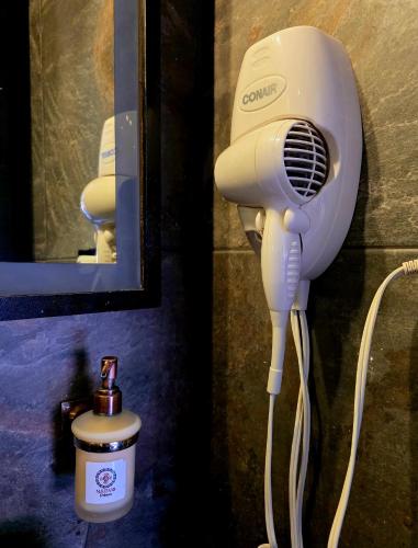 a hair dryer hanging on a wall next to a mirror at Habitación Deluxe 1 con Jacuzzi a 20mt del parque in Salento