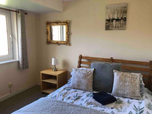 a bedroom with a bed and a mirror on the wall at Central with River Views in Chesterton