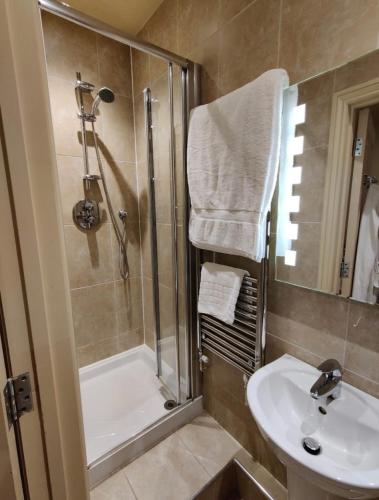 a bathroom with a shower and a sink and a tub at Masons Arms in Montacute