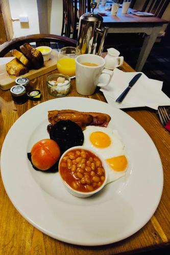 a plate of food with eggs and beans on a table at Masons Arms in Montacute