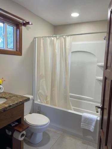 a bathroom with a shower curtain and a toilet at K S G Cabanas in Dangriga