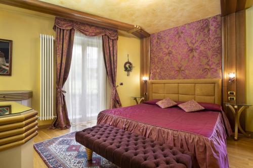a bedroom with a purple bed and a window at Hotel Luis in Fiera di Primiero