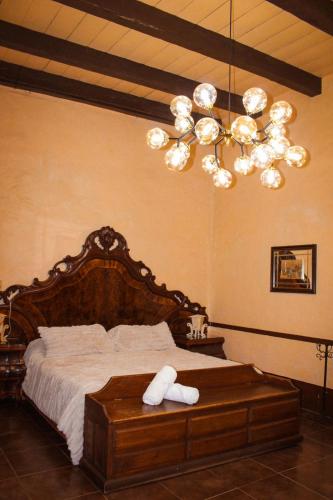 a bedroom with a large bed with a chandelier at Hotel y restaurante Cuenca Antigua in Mazamitla