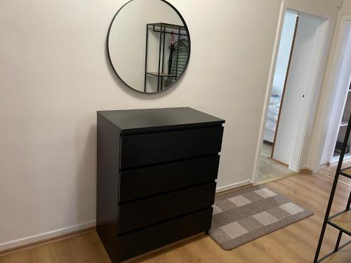 a black dresser in a room with a mirror at Sunny apartment Trutnov in Trutnov
